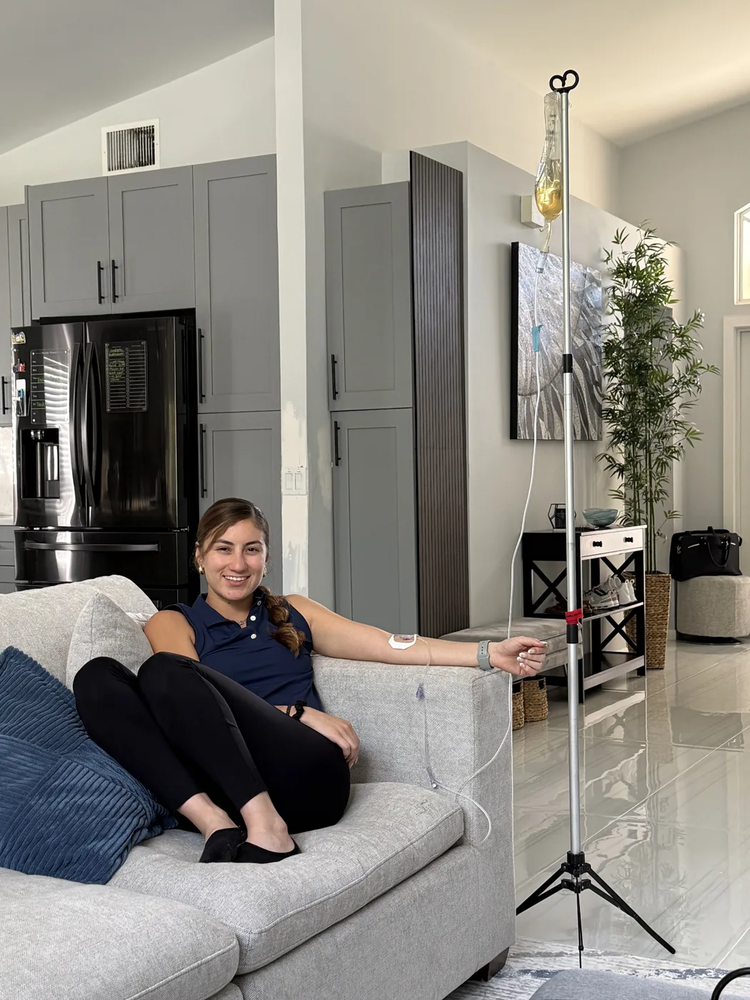 Client relaxing on her couch during a mobile IV vitamin drip at home in Palm Beach County